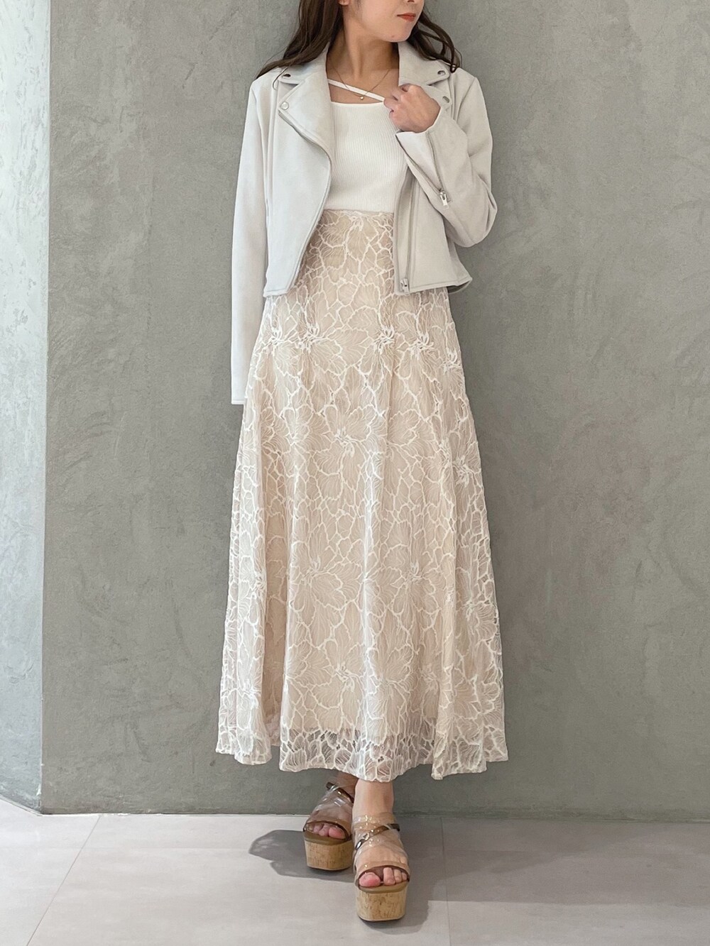 ブラウン系のサンダル、ホワイト系のニット/セーター、ホワイト系のライダースジャケットを着用したレディースの春コーディネートの7枚目の写真