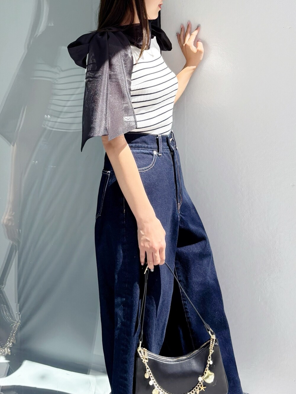 ブルー系のデニムパンツ、その他のニット/セーター、ホワイト系のサンダルを着用したレディースの夏コーディネートの4枚目の写真