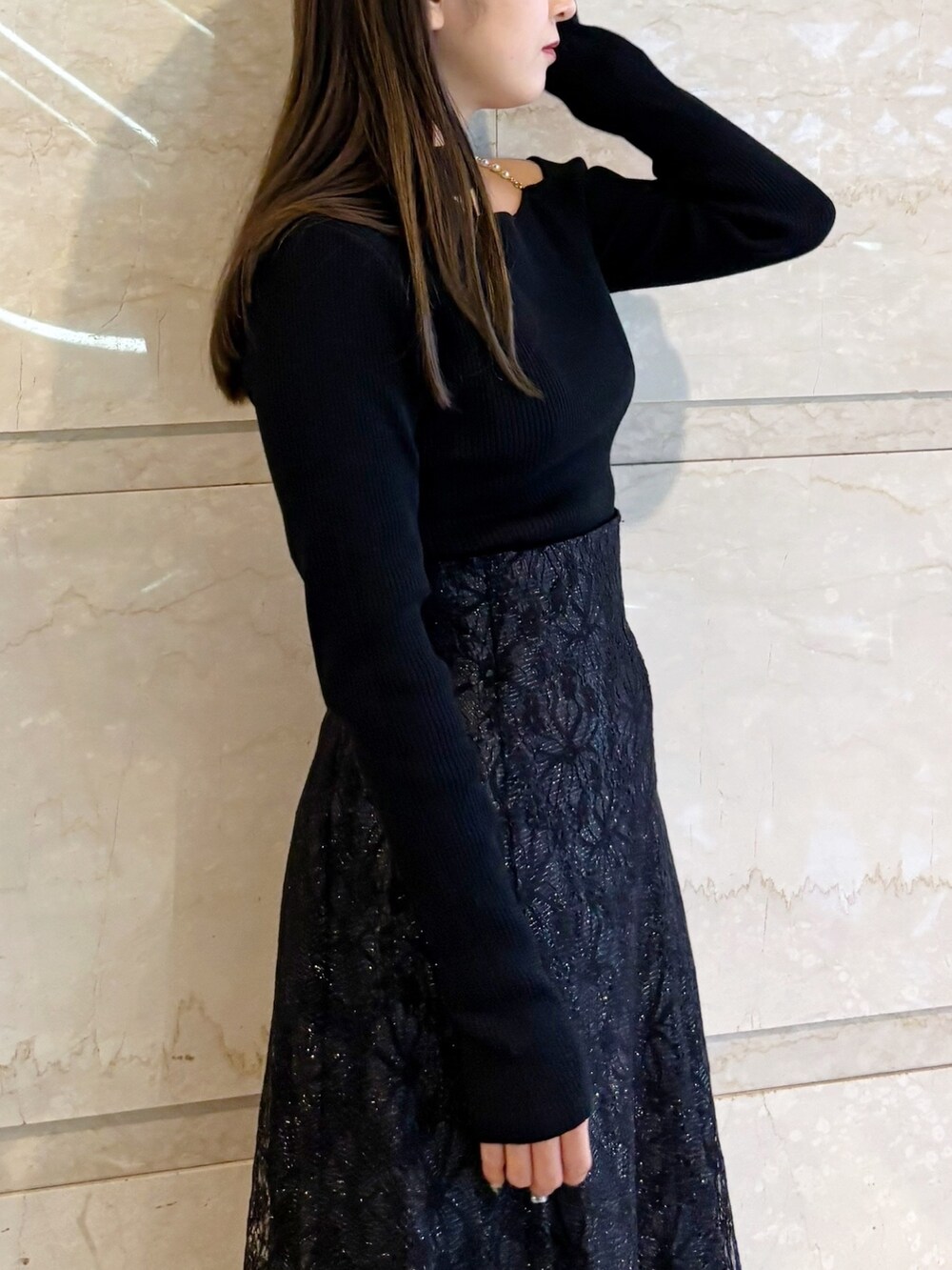 ブラック系のスカート、ブラック系のニット/セーター、ブラック系のブーツを着用したレディースの冬コーディネートの4枚目の写真