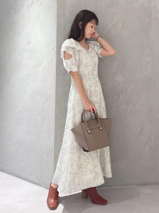 イエロー系のワンピース、ブラック系のサンダル、ブラウン系のハンドバッグを着用したレディースの夏コーディネートの7枚目の写真