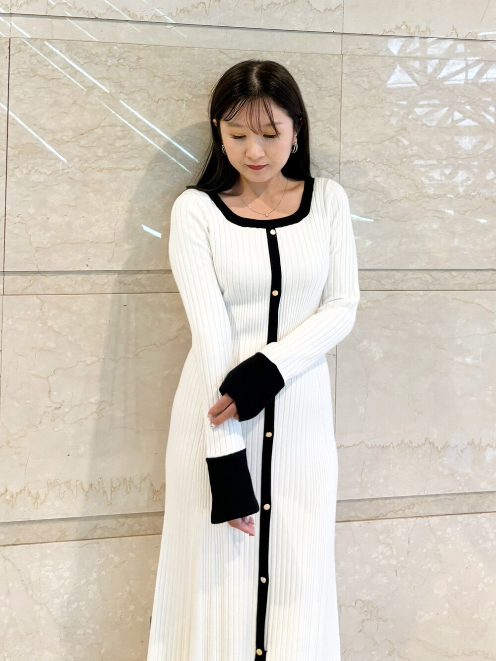 ホワイト系のワンピース、ブラック系のブーツを着用したレディースの冬コーディネートの4枚目の写真