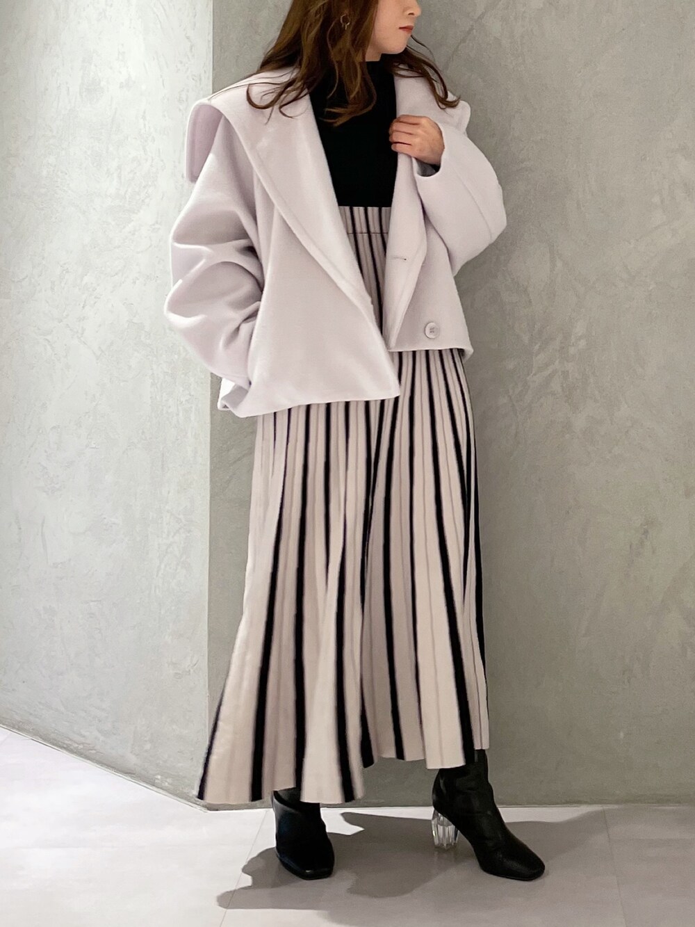 ブラック系のワンピース、グレー系のその他アウター、ブラック系のブーツを着用したレディースの冬コーディネートの4枚目の写真