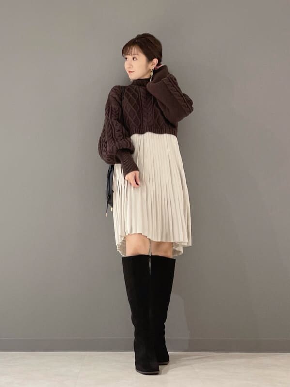 ベージュ系のショルダーバッグ、ブラウン系のワンピース、ゴールド系のピアス（両耳用）を着用したレディースの冬コーディネートの6枚目の写真