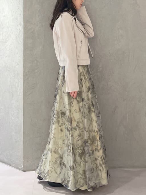 グレー系のライダースジャケット、イエロー系のスカート、ホワイト系のニット/セーターを着用したレディースの秋コーディネートの3枚目の写真