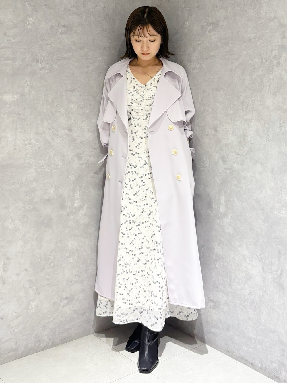 ホワイト系のワンピース、ブラック系のブーツ、パープル系のトレンチコートを着用したレディースの冬コーディネートの5枚目の写真