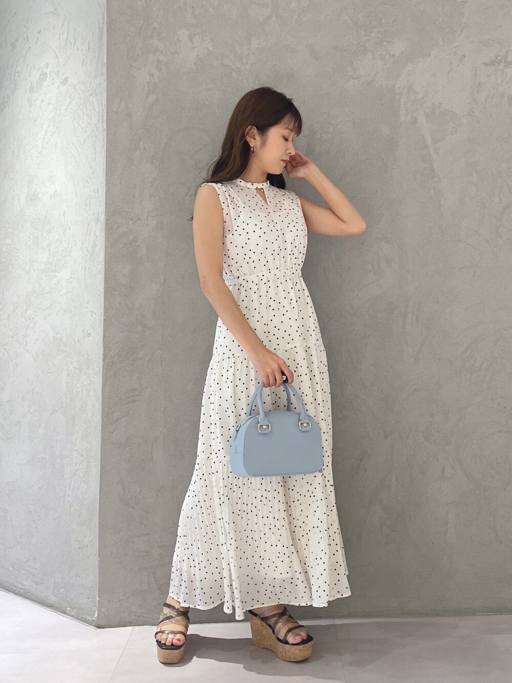 ホワイト系のワンピース、ブラック系のサンダル、ブルー系のボストンバッグを着用したレディースの夏コーディネートの2枚目の写真