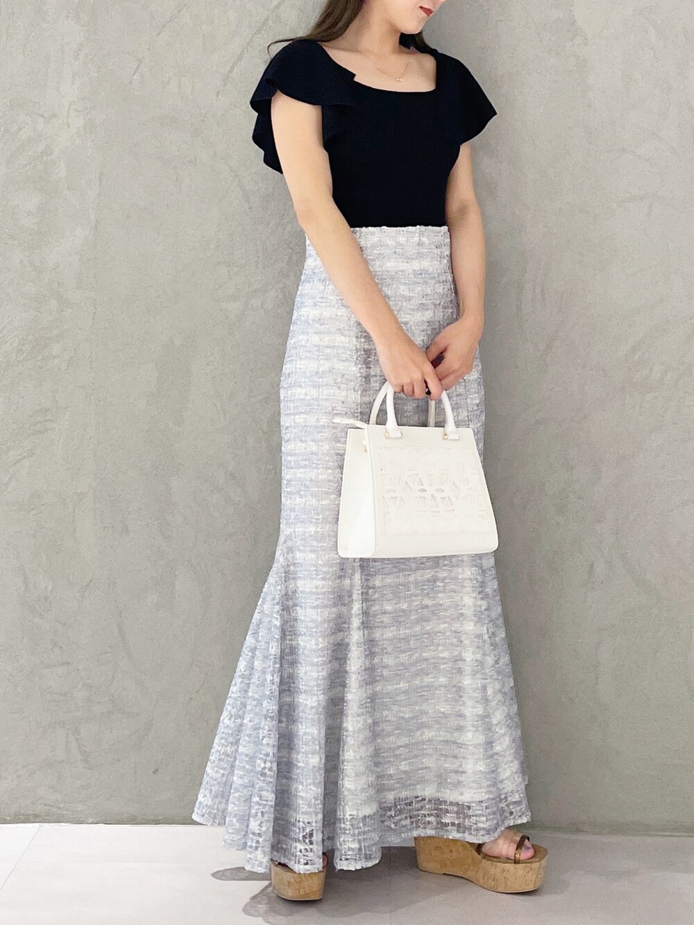 ホワイト系のショルダーバッグ、ブラック系のニット/セーター、ブラウン系のサンダルを着用したレディースの春コーディネートの4枚目の写真