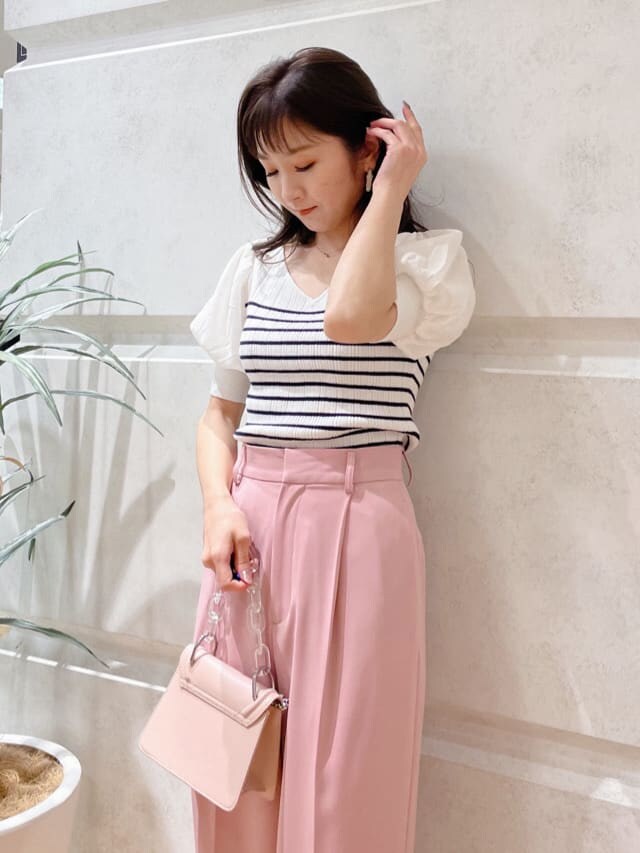 ベージュ系のパンプス、ピンク系のショルダーバッグ、ホワイト系のニット/セーターを着用したレディースの春コーディネートの2枚目の写真