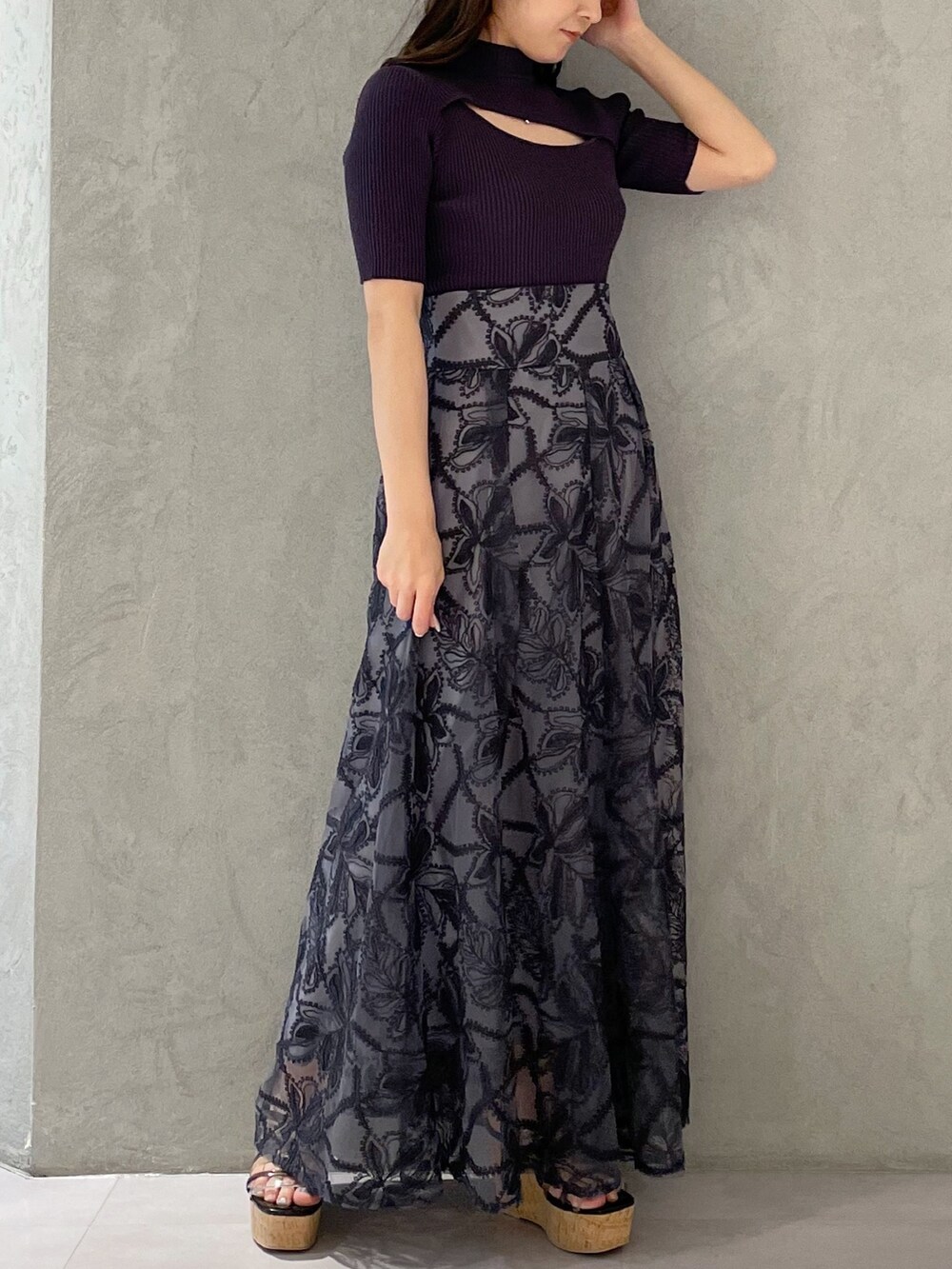 グレー系のスカート、ブラック系のサンダル、グレー系のニット/セーターを着用したレディースの春コーディネートの2枚目の写真