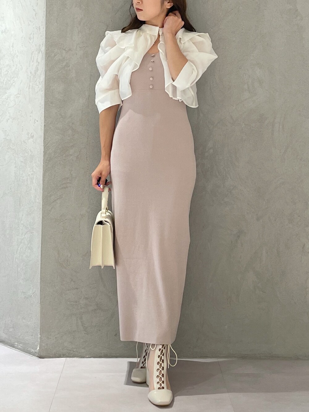 ベージュ系のワンピース、ホワイト系のブーツ、ホワイト系のハンドバッグを着用したレディースの夏コーディネートの2枚目の写真