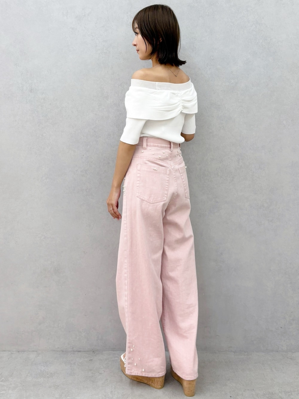 ピンク系のデニムパンツ、その他のサンダル、ホワイト系のニット/セーターを着用したレディースの春コーディネートの5枚目の写真