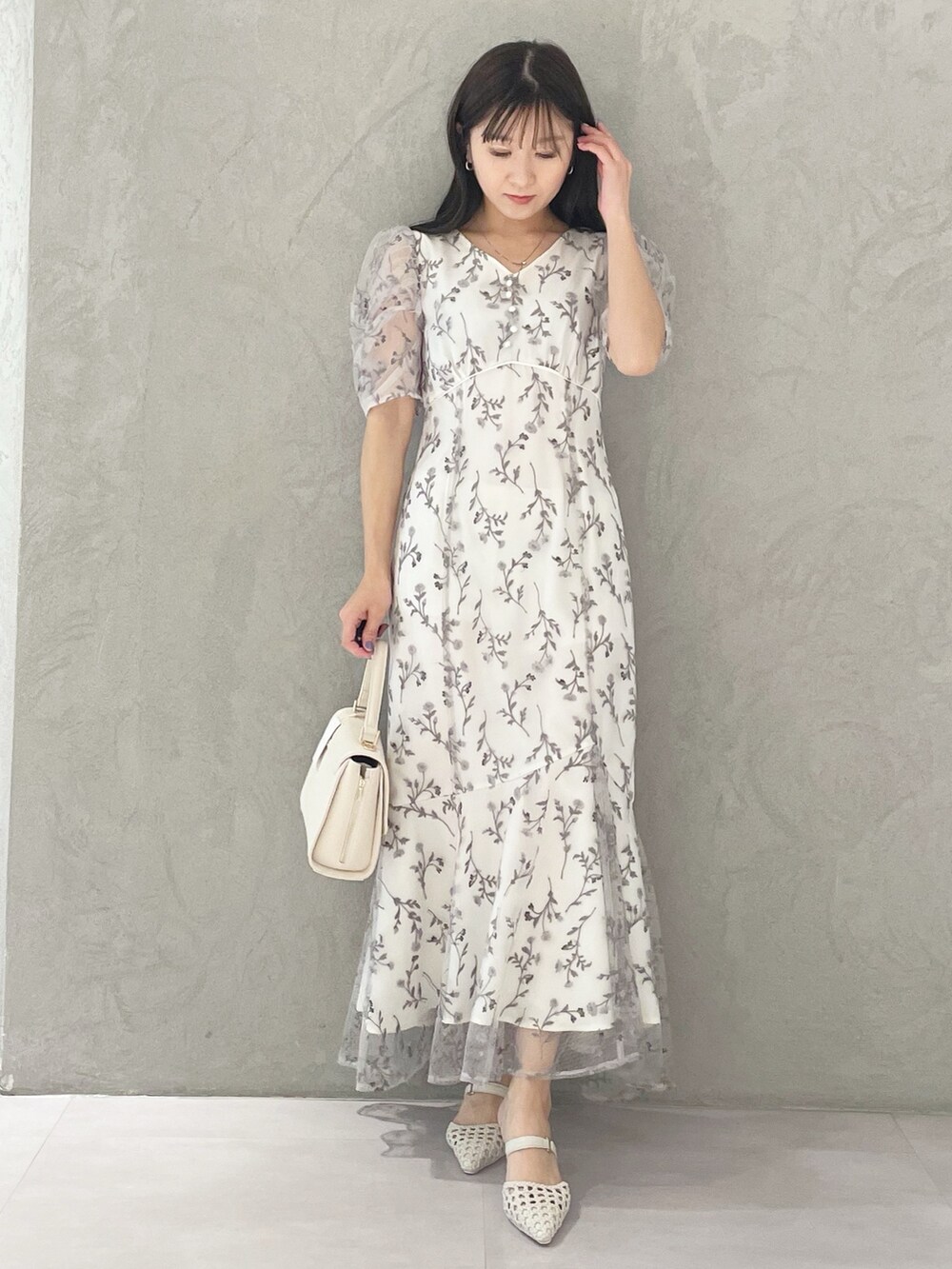 ホワイト系のショルダーバッグ、ホワイト系のパンプス、グレー系のワンピースを着用したレディースの春コーディネートの5枚目の写真