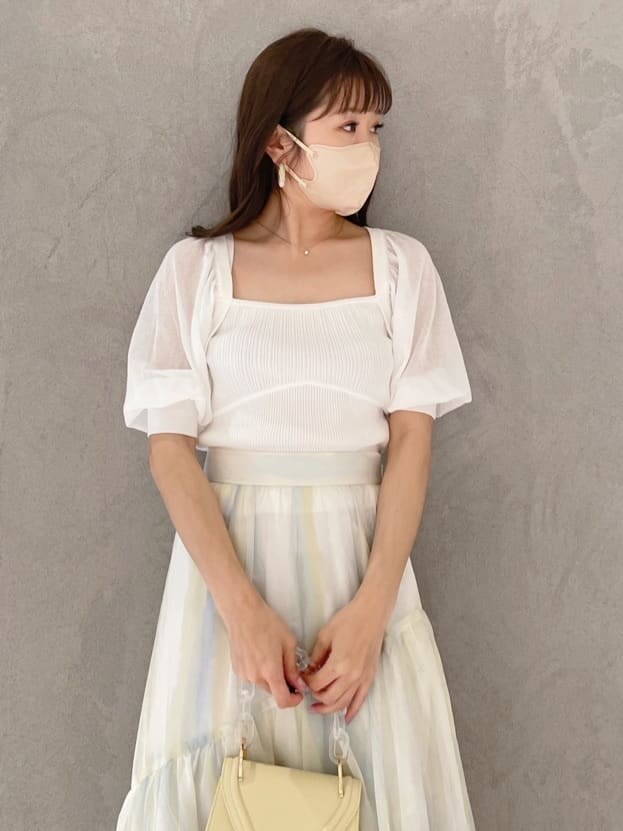 グリーン系のサンダル、グリーン系のスカート、ホワイト系のニット/セーターを着用したレディースの春コーディネートの2枚目の写真