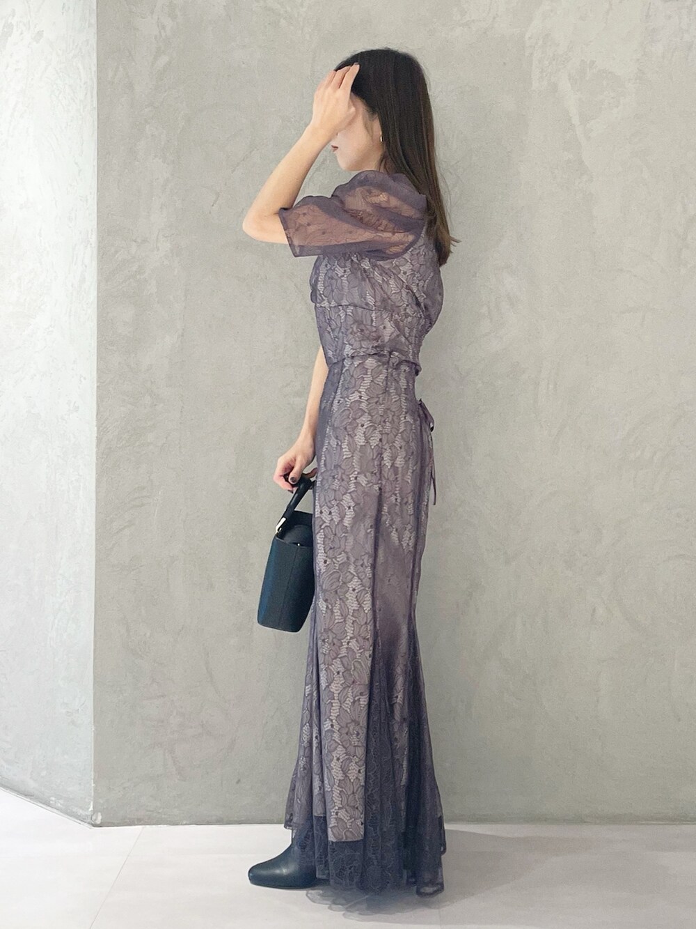 パープル系のシャツ/ブラウス、ブラック系のハンドバッグ、ブラック系のブーツを着用したレディースの冬コーディネートの2枚目の写真