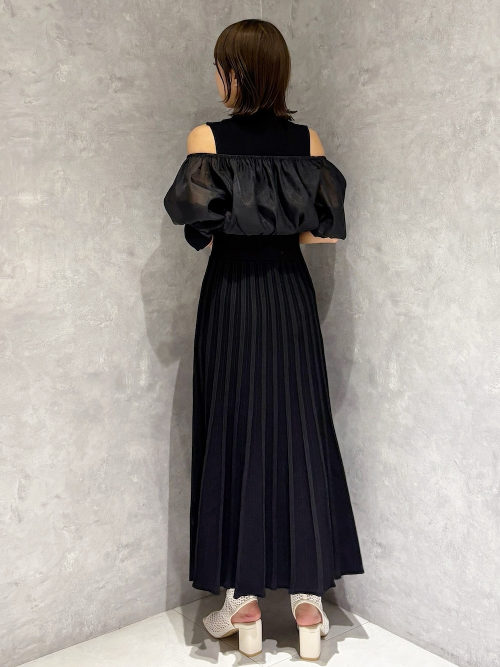 ブラウン系のハンドバッグ、ブラック系のワンピースを着用したレディースの春コーディネートの3枚目の写真