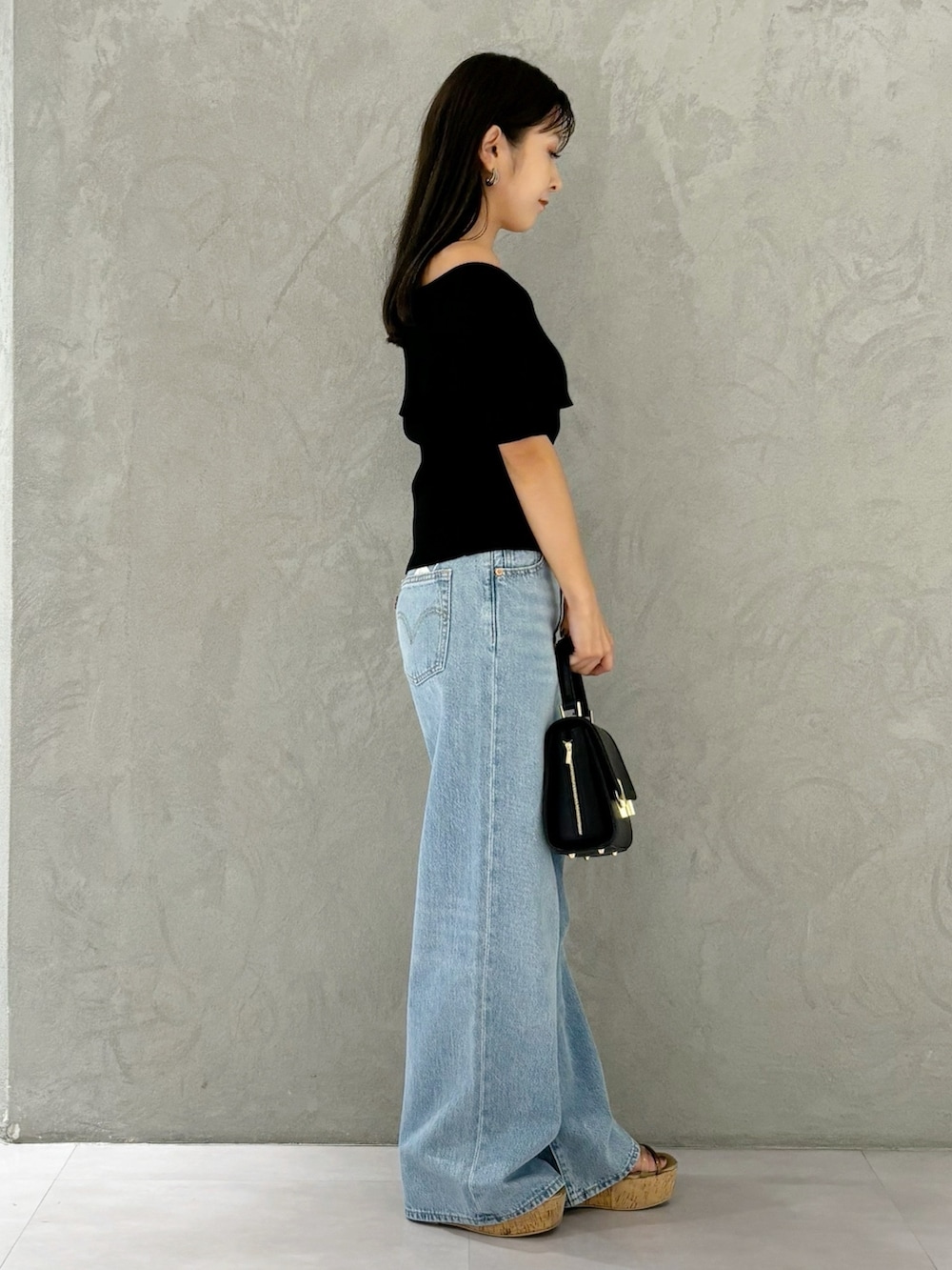 ブラック系のニット/セーター、ブラウン系のサンダル、ブラック系のショルダーバッグを着用したレディースの夏コーディネートの4枚目の写真