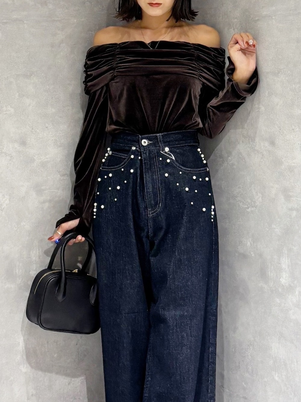 ブルー系のデニムパンツ、ブラウン系のTシャツ/カットソー、ブラウン系のブーツを着用したレディースの秋コーディネートの5枚目の写真