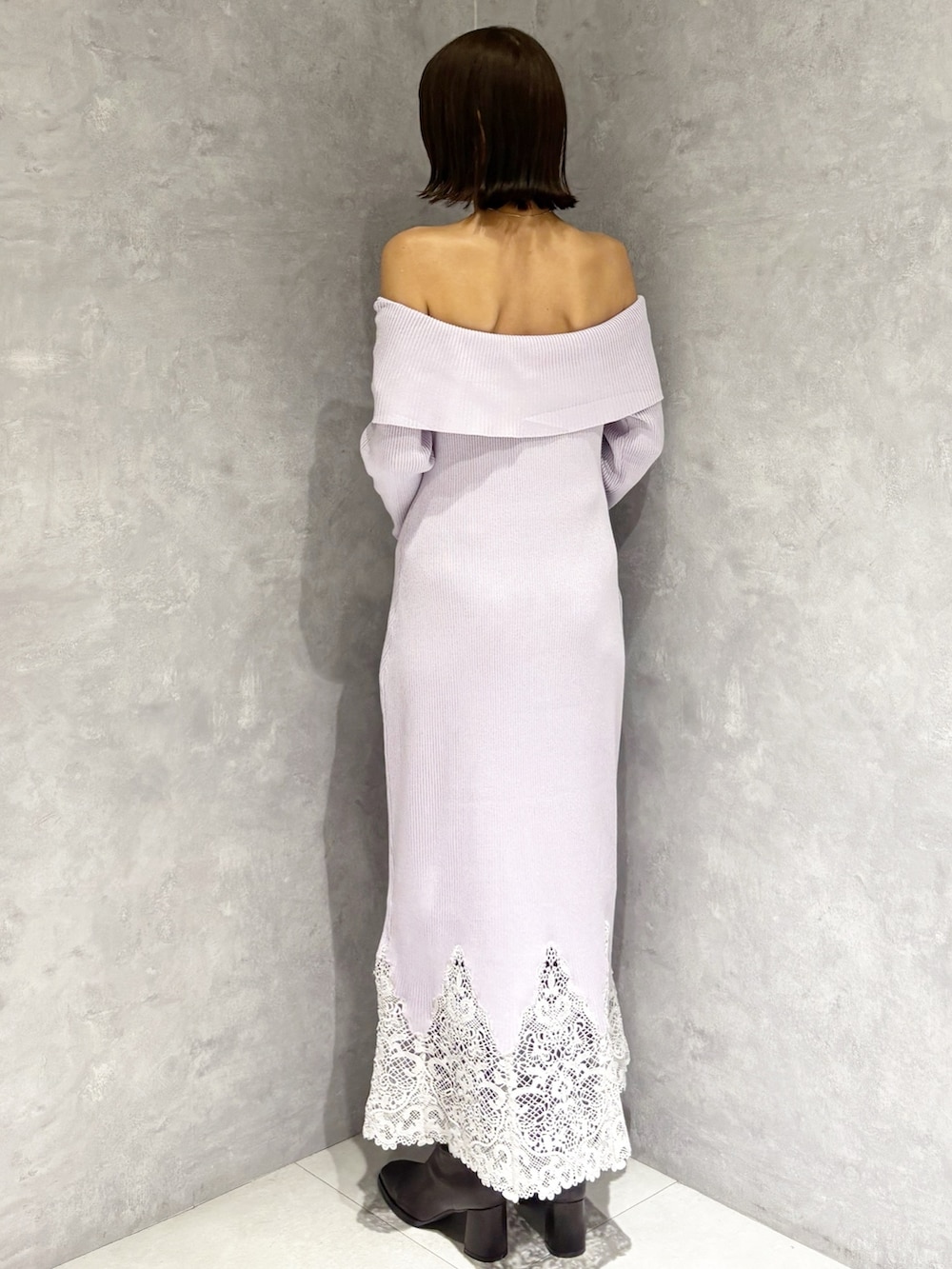 パープル系のワンピース、ブラック系のハンドバッグ、ブラウン系のブーツを着用したレディースの秋コーディネートの3枚目の写真