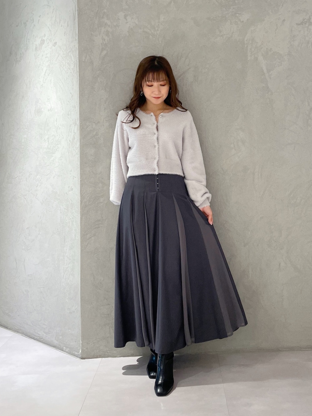 グレー系のカーディガン/ボレロ、グレー系のスカート、ブラック系のブーツを着用したレディースの冬コーディネートの4枚目の写真
