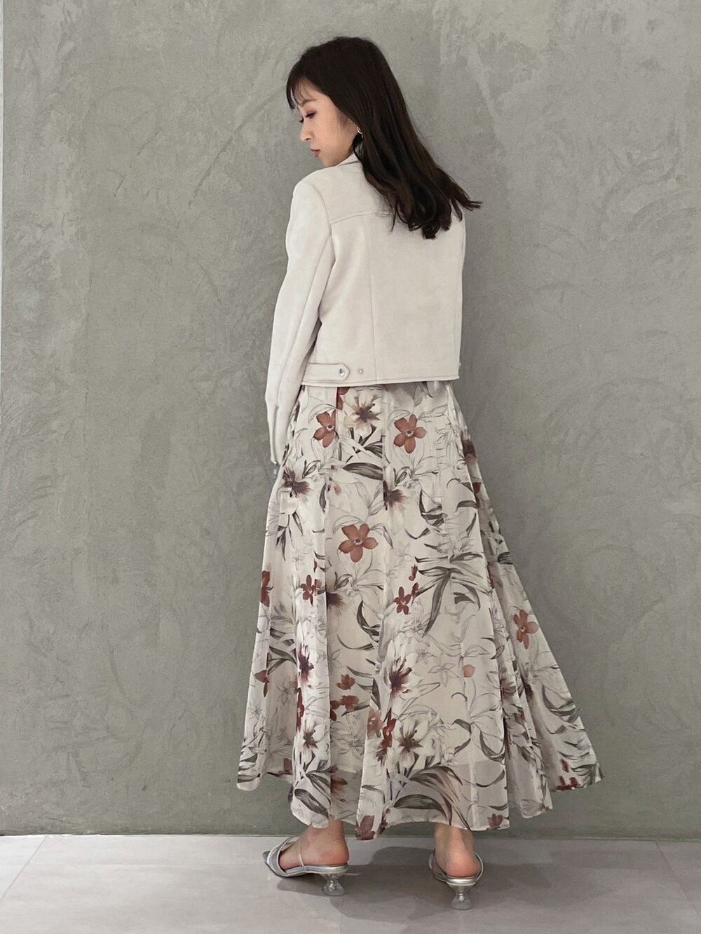 ピンク系のスカート、ピンク系のライダースジャケット、レッド系のニット/セーターを着用したレディースの春コーディネートの6枚目の写真