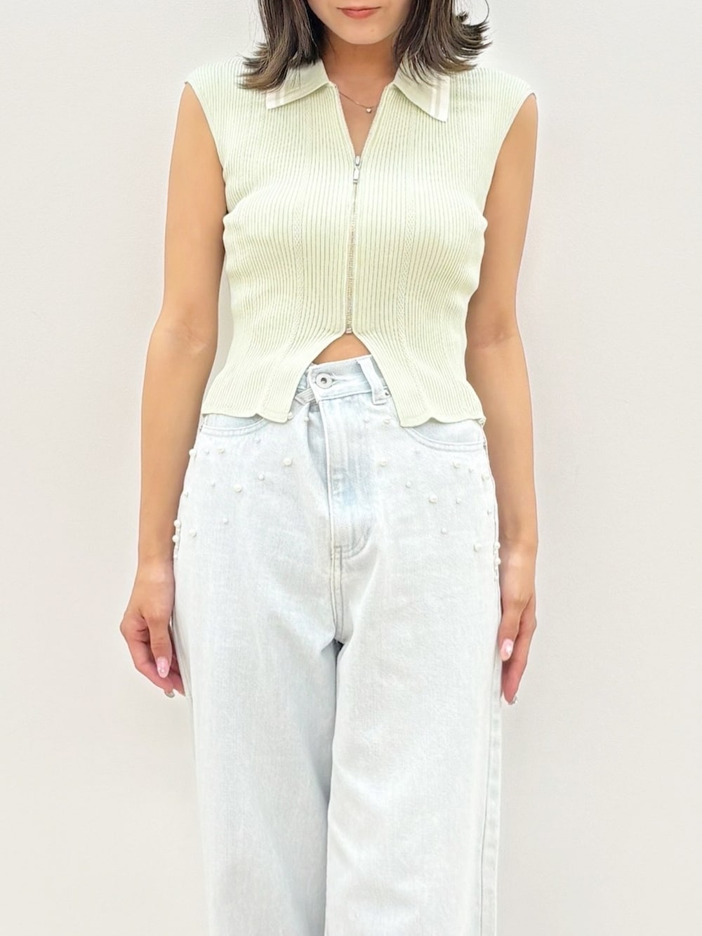 ブルー系のデニムパンツ、グリーン系のニット/セーターを着用したレディースの夏コーディネートの6枚目の写真