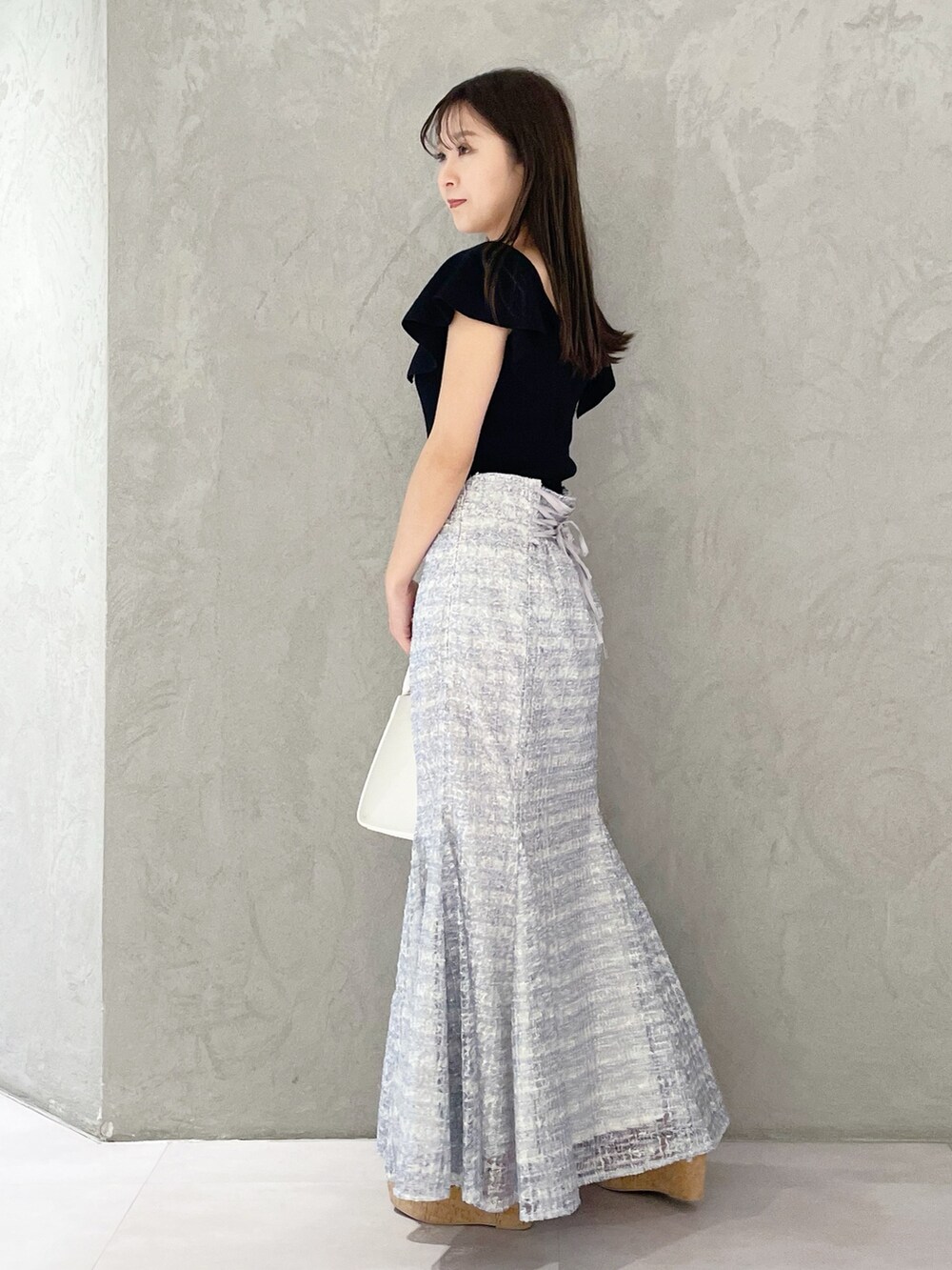 ホワイト系のショルダーバッグ、ブラック系のニット/セーター、ブラウン系のサンダルを着用したレディースの春コーディネートの3枚目の写真