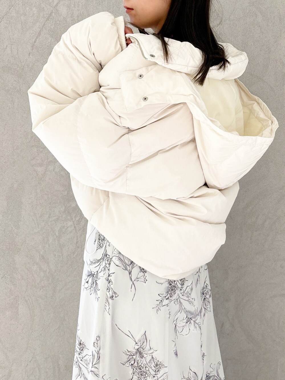 ブラック系のワンピース、ブラック系のブーツ、ホワイト系のハンドバッグを着用したレディースの秋コーディネートの3枚目の写真