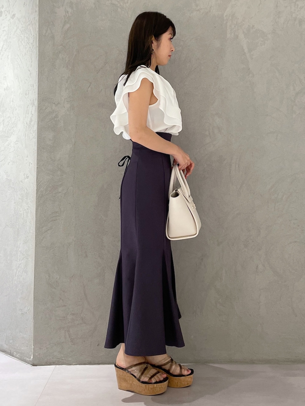 ブラック系のサンダル、ホワイト系のトートバッグ、ホワイト系のシャツ/ブラウスを着用したレディースの春コーディネートの2枚目の写真