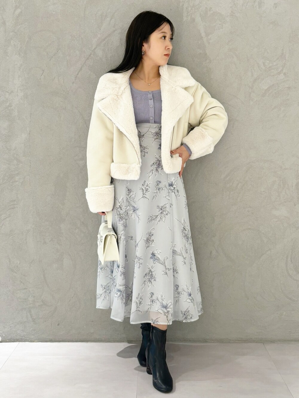 パープル系のワンピース、ブラック系のブーツ、ホワイト系のショルダーバッグを着用したレディースの秋コーディネートの5枚目の写真