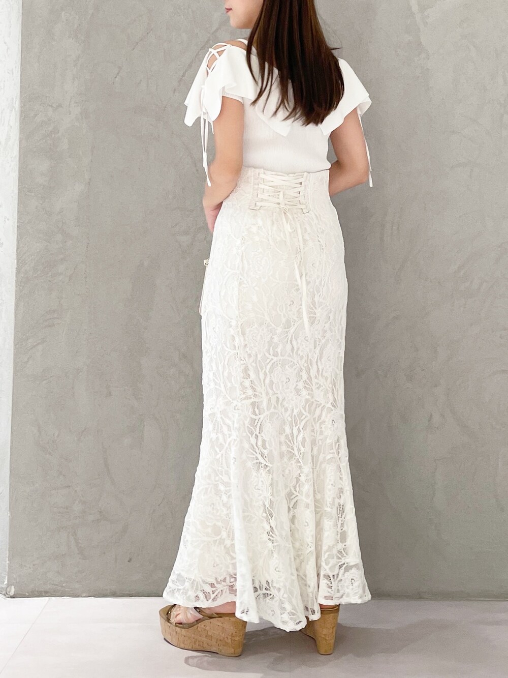 ホワイト系のハンドバッグ、ホワイト系のニット/セーター、ホワイト系のスカートを着用したレディースの春コーディネートの3枚目の写真