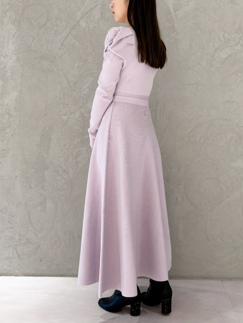 ホワイト系のショルダーバッグ、ブラック系のブーツ、パープル系のワンピースを着用したレディースの冬コーディネートの3枚目の写真