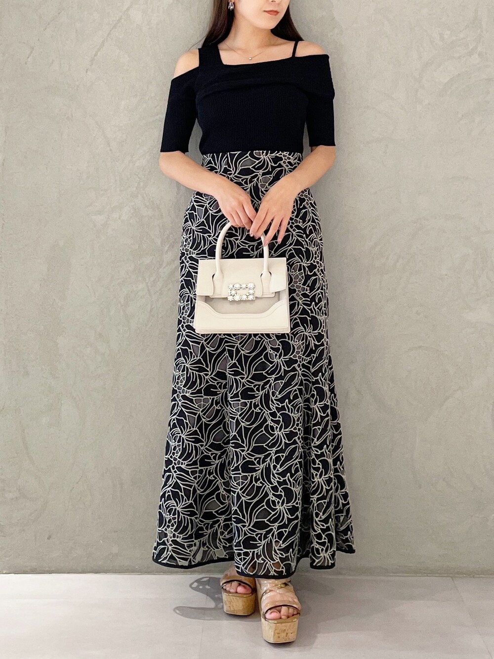 ブラック系のスカート、ブラウン系のサンダル、ベージュ系のショルダーバッグを着用したレディースの夏コーディネートの5枚目の写真