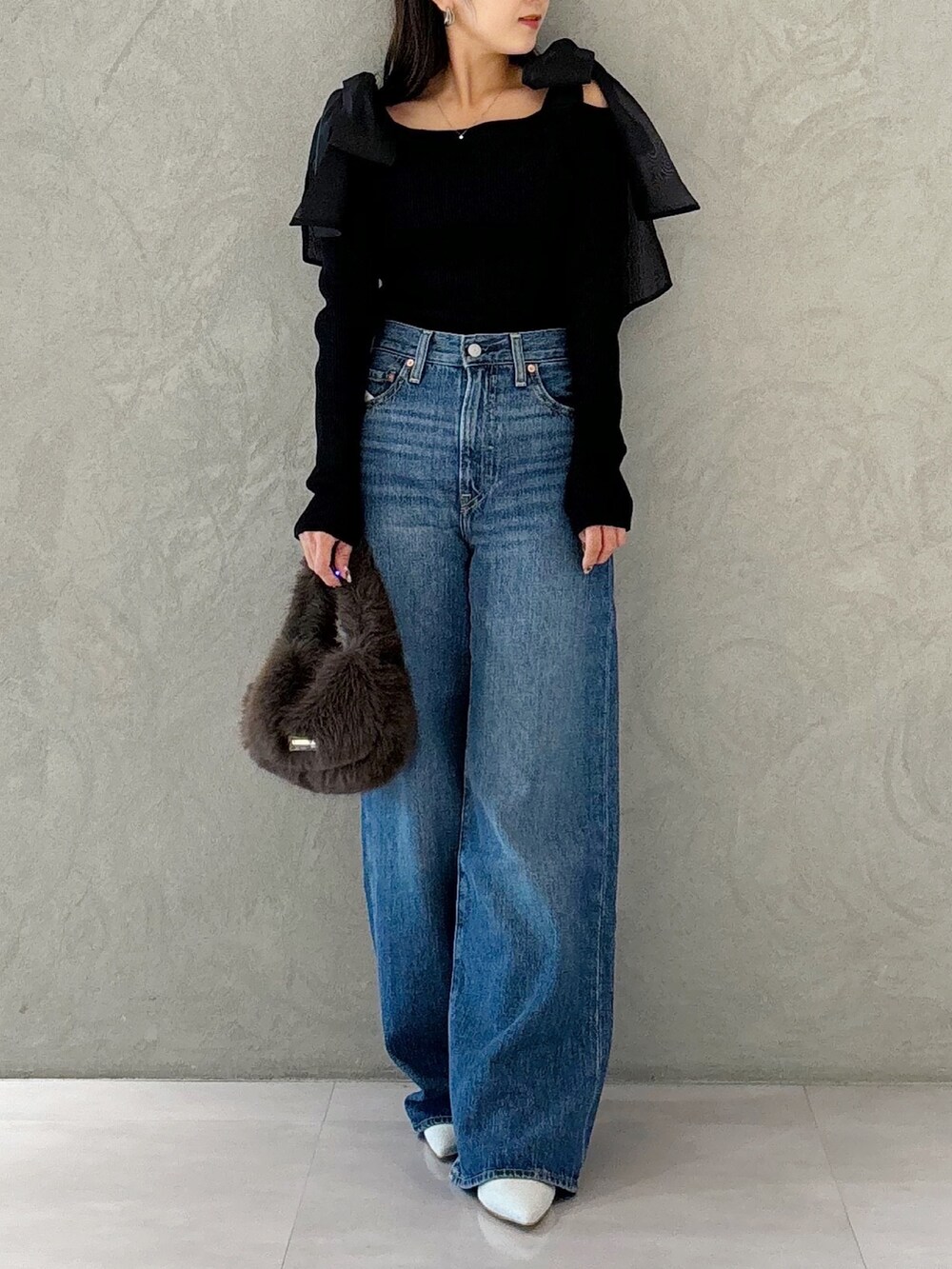 ブラウン系のハンドバッグ、シルバー系のパンプス、ブラック系のニット/セーターを着用したレディースの秋コーディネートの8枚目の写真