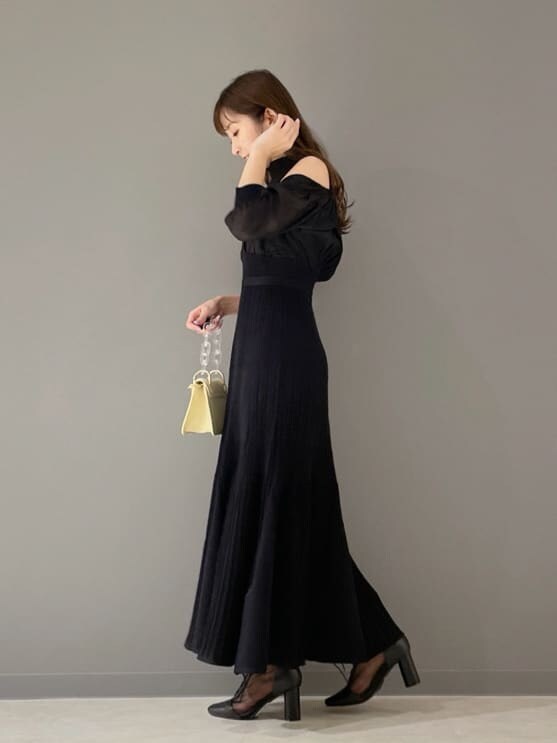 ブラック系のその他シューズ、ブラック系のワンピース、イエロー系のショルダーバッグを着用したレディースの冬コーディネートの2枚目の写真