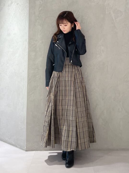 ブラック系のライダースジャケット、ブラック系のニット/セーター、ベージュ系のスカートを着用したレディースの秋コーディネートの5枚目の写真