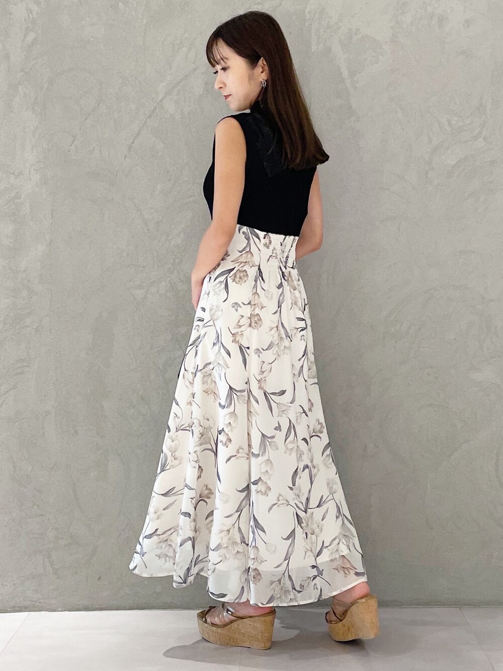 ブラック系のワンピース、ブラウン系のサンダル、ブラック系のハンドバッグを着用したレディースの夏コーディネートの3枚目の写真