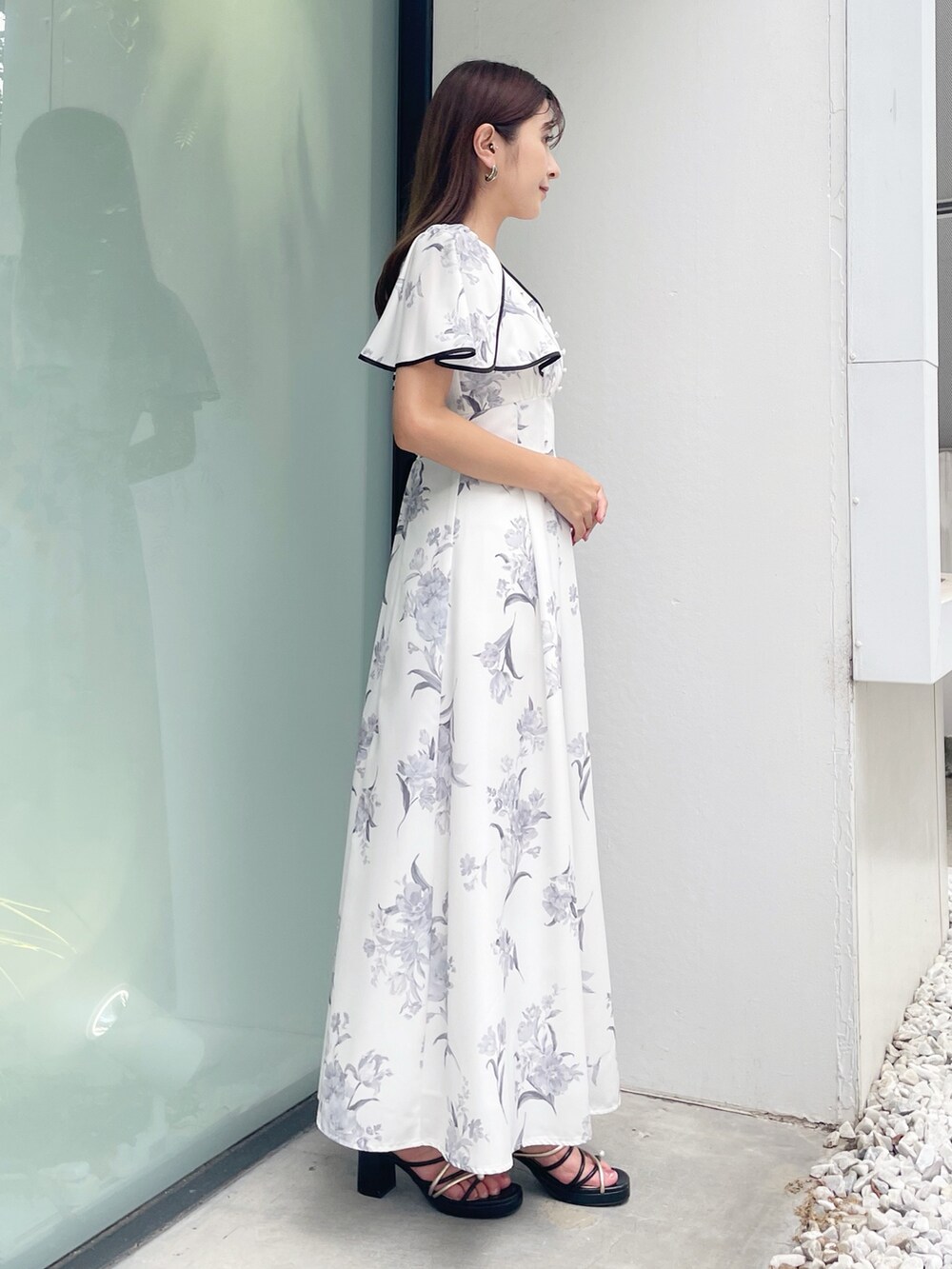 ブラック系のサンダル、ホワイト系のワンピースを着用したレディースの夏コーディネートの4枚目の写真