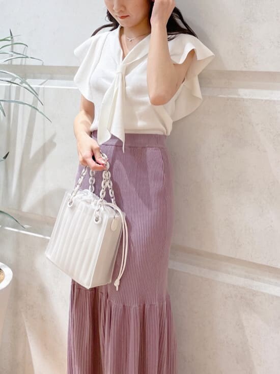 ホワイト系のハンドバッグ、ホワイト系のニット/セーター、グリーン系のサンダルを着用したレディースの春コーディネートの5枚目の写真