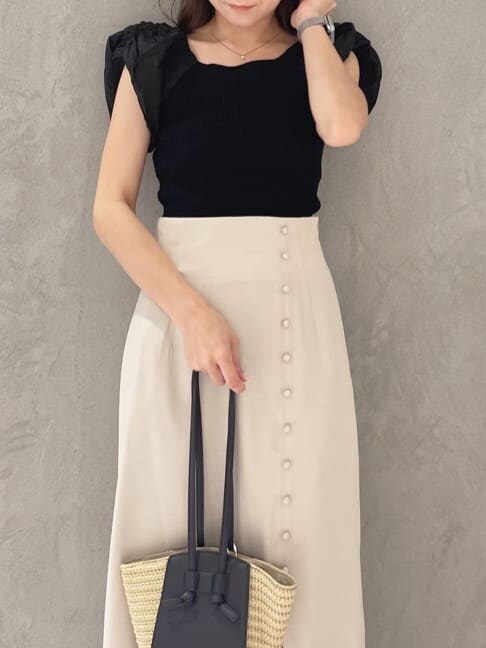 グリーン系のサンダル、ブラック系のニット/セーター、ベージュ系のスカートを着用したレディースの夏コーディネートの2枚目の写真