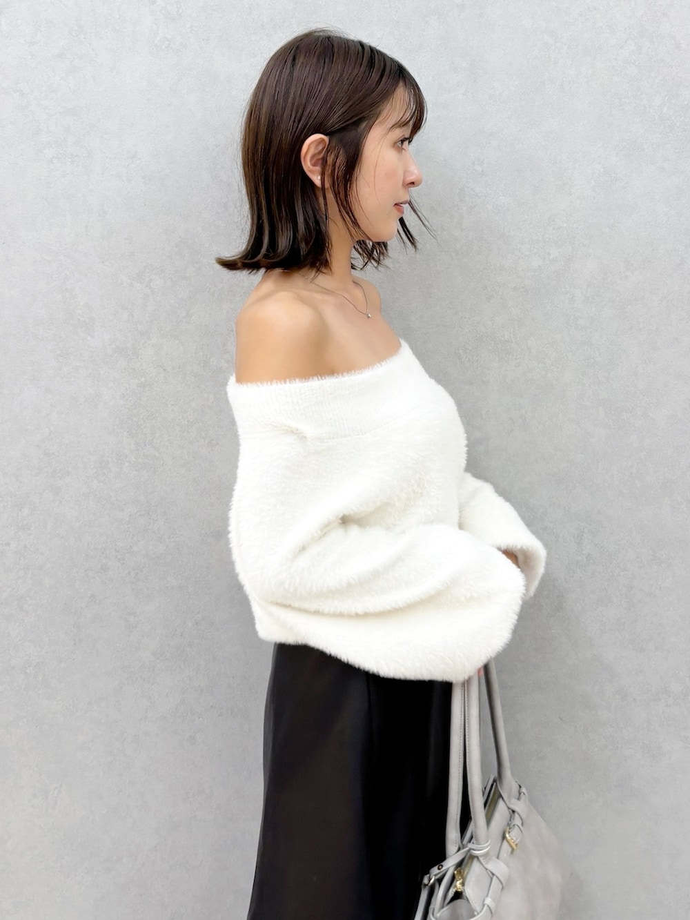 ブラック系のスカート、ホワイト系のブーツ、ホワイト系のニット/セーターを着用したレディースの秋コーディネートの4枚目の写真