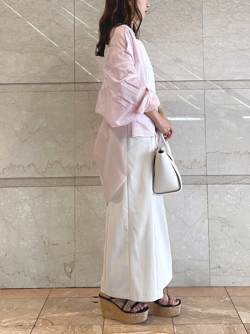 ホワイト系のトートバッグ、ブラック系のサンダル、ベージュ系のワンピースを着用したレディースの夏コーディネートの4枚目の写真