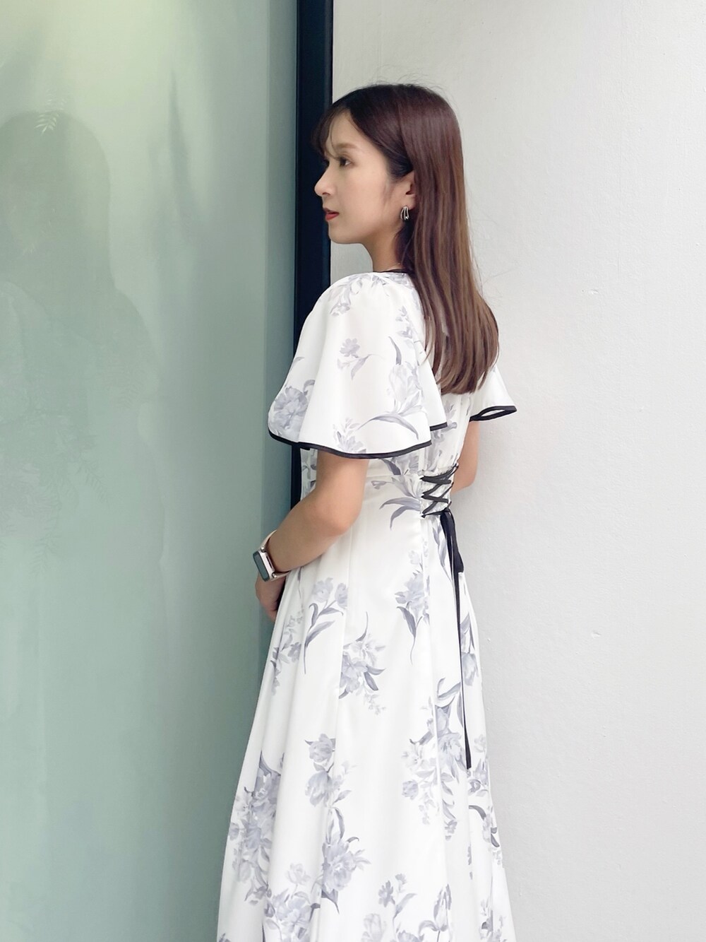 ブラック系のサンダル、ホワイト系のワンピースを着用したレディースの夏コーディネートの5枚目の写真