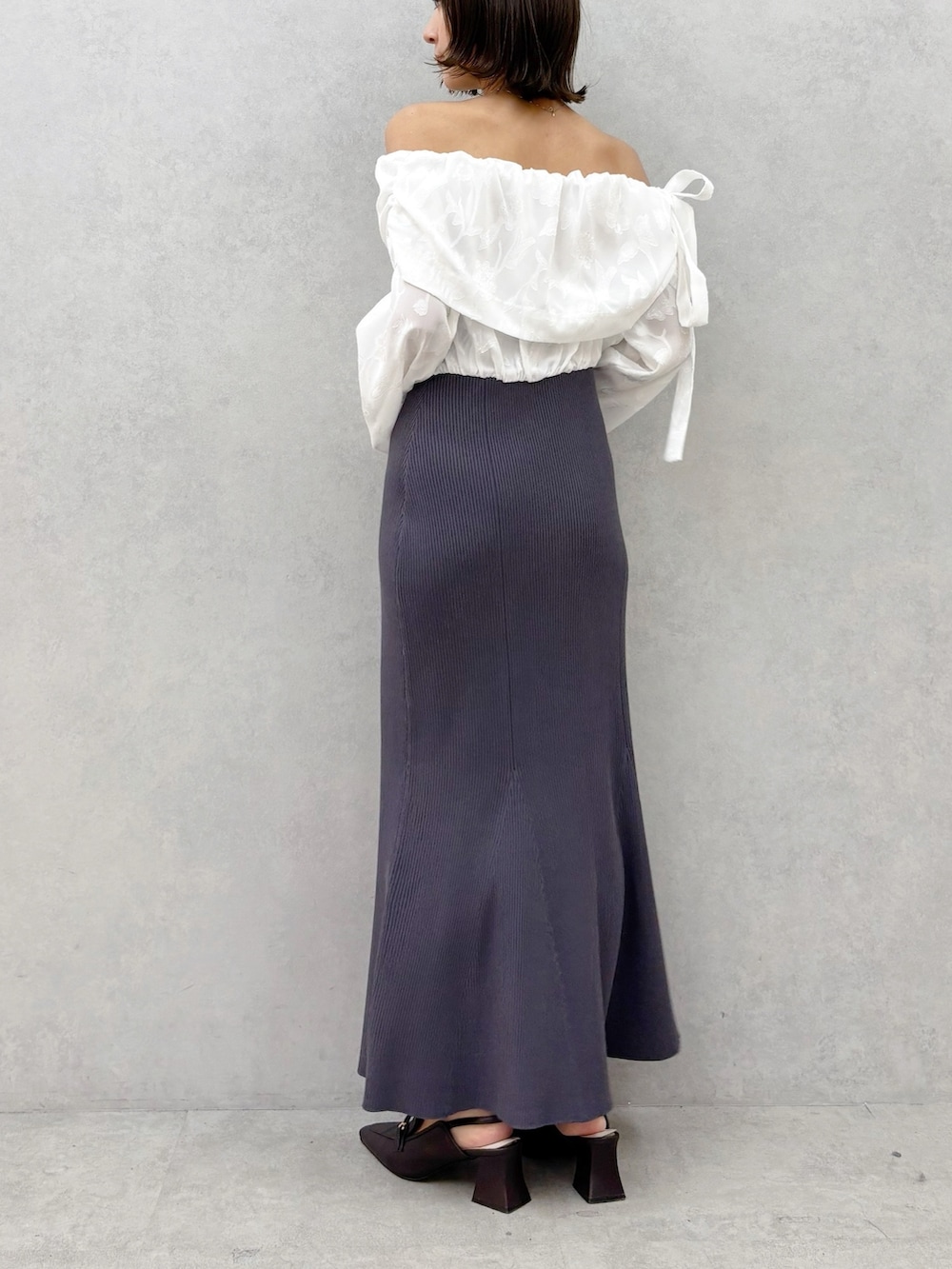 ブラウン系のパンプス、グレー系のワンピースを着用したレディースの冬コーディネートの5枚目の写真