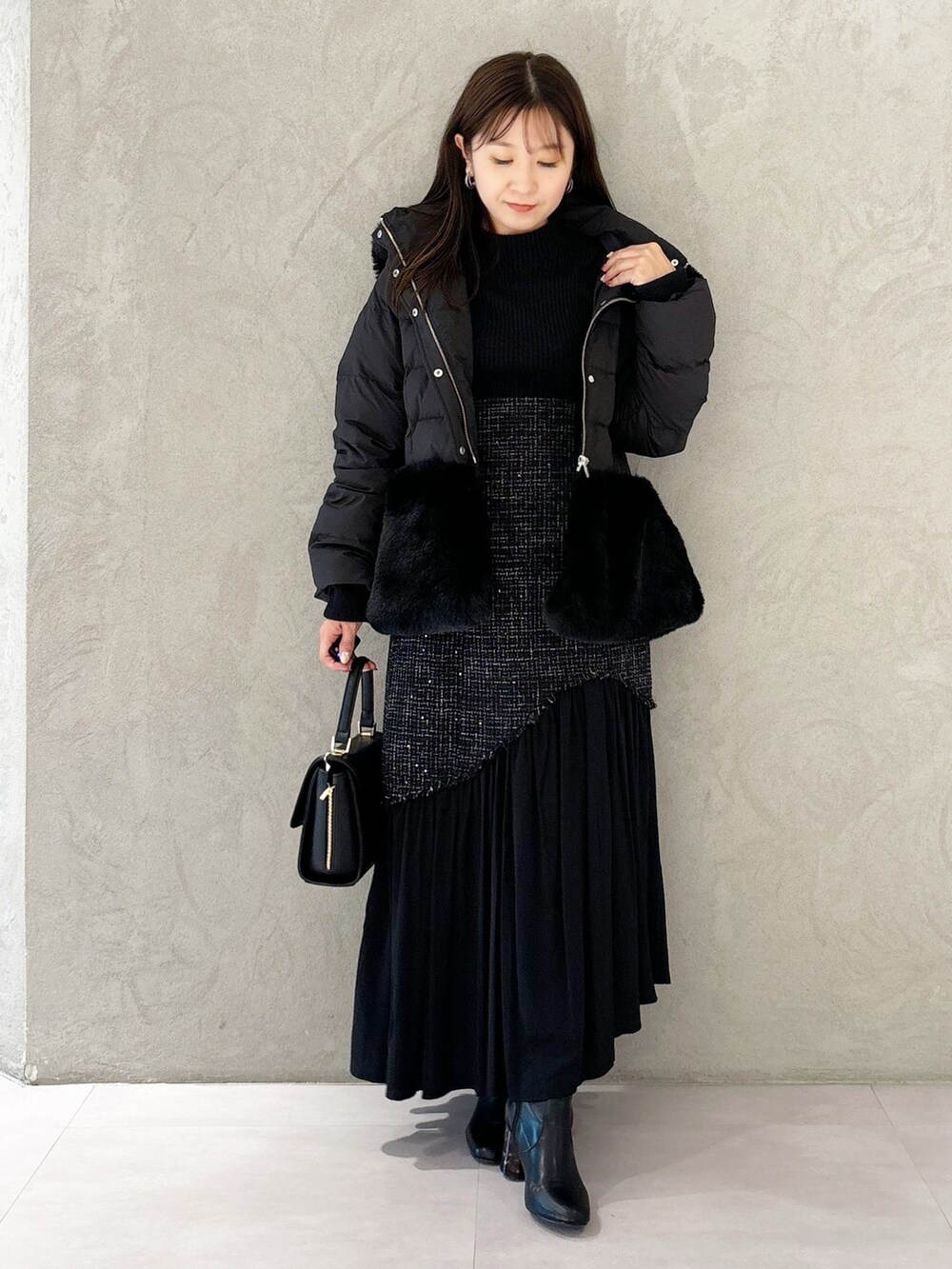 ブラック系のスカート、ブラック系のブーツ、ブラック系のショルダーバッグを着用したレディースの秋コーディネートの8枚目の写真
