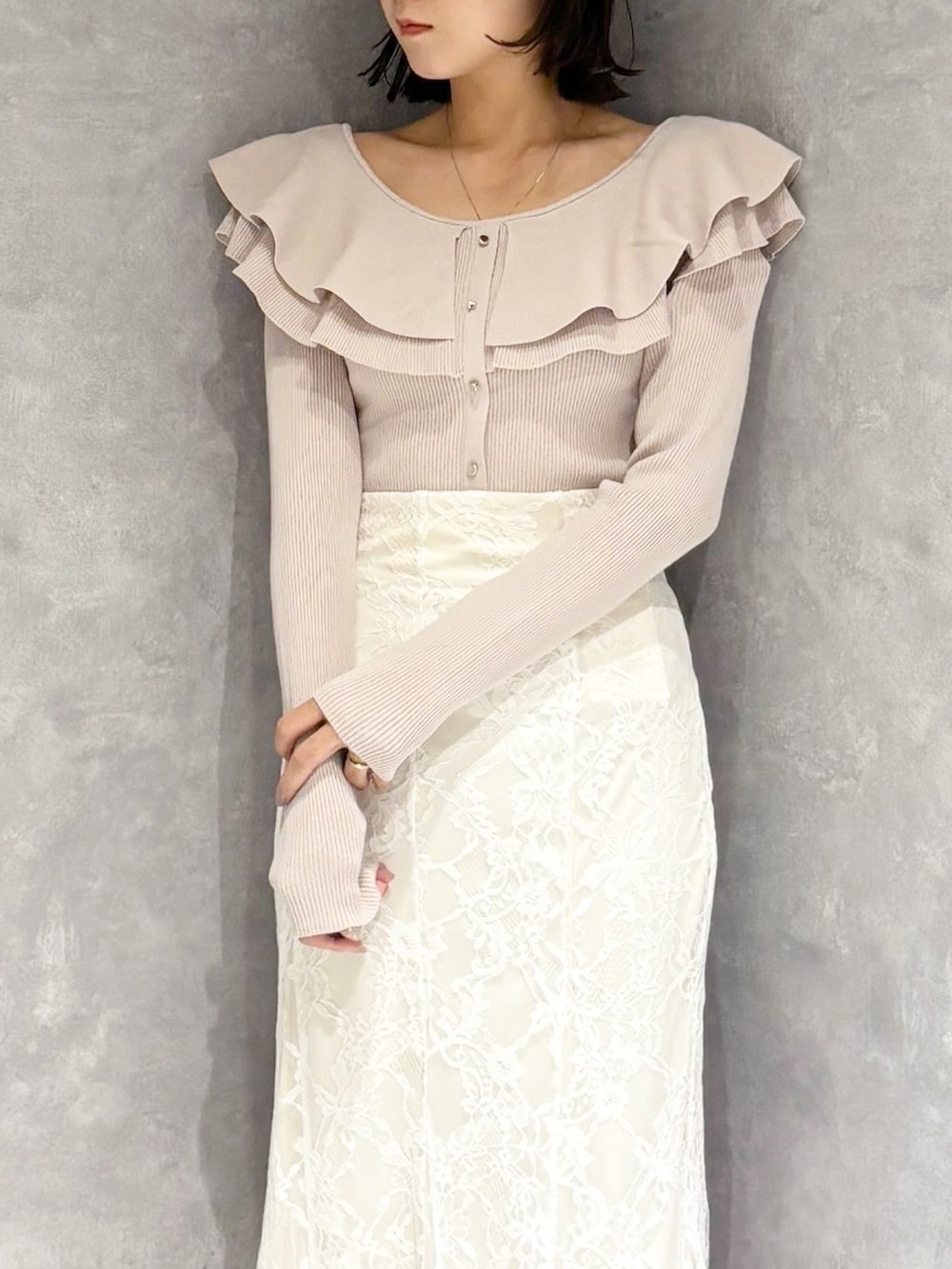 ホワイト系のスカート、ベージュ系のニット/セーター、ブラック系のブーツを着用したレディースの冬コーディネートの5枚目の写真