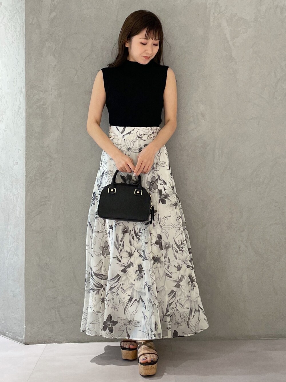 ホワイト系のボストンバッグ、ホワイト系のスカート、ブラック系のニット/セーターを着用したレディースの春コーディネートの7枚目の写真