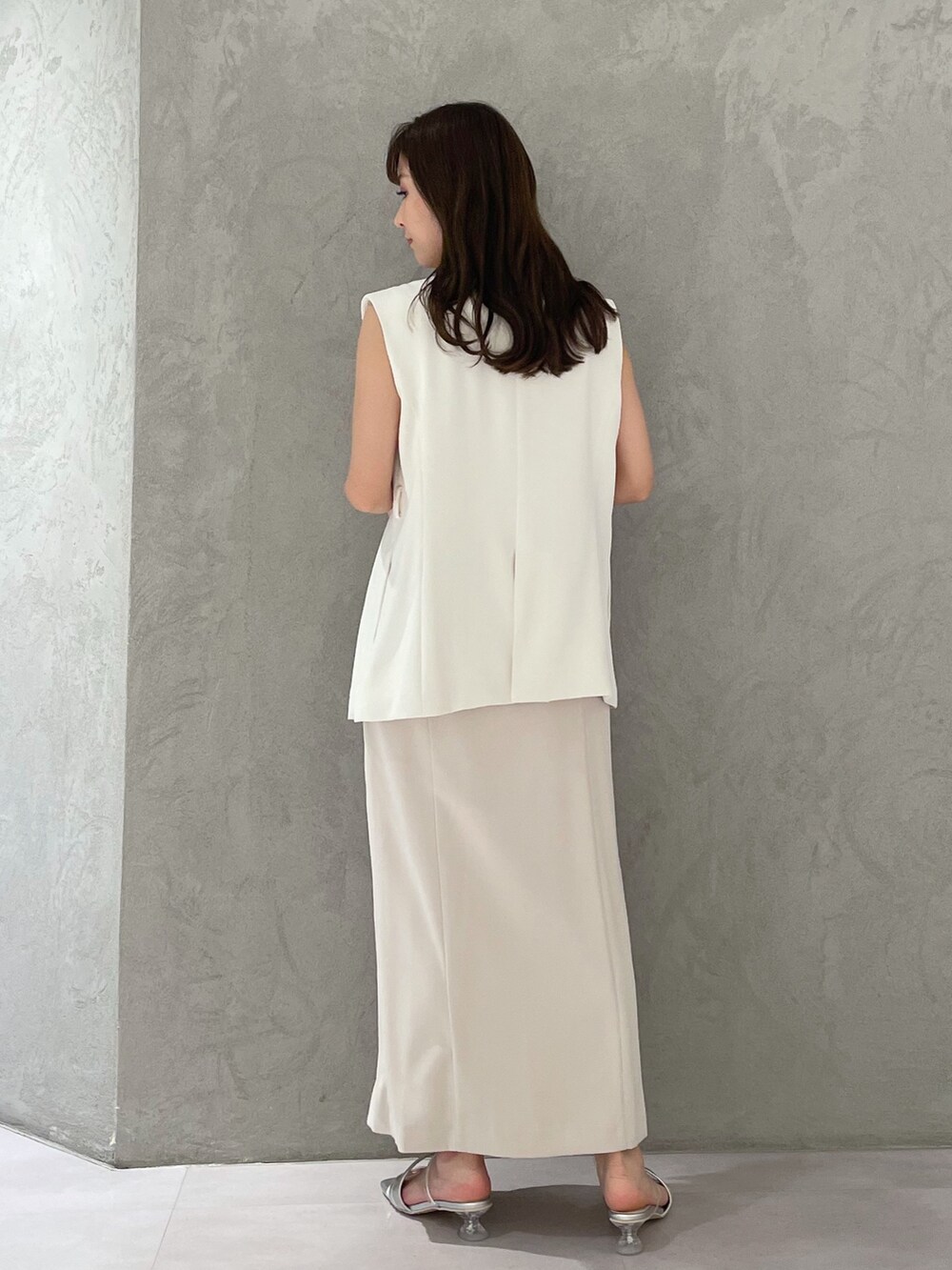 ホワイト系のワンピース、シルバー系のサンダル、ホワイト系のベストを着用したレディースの春コーディネートの4枚目の写真