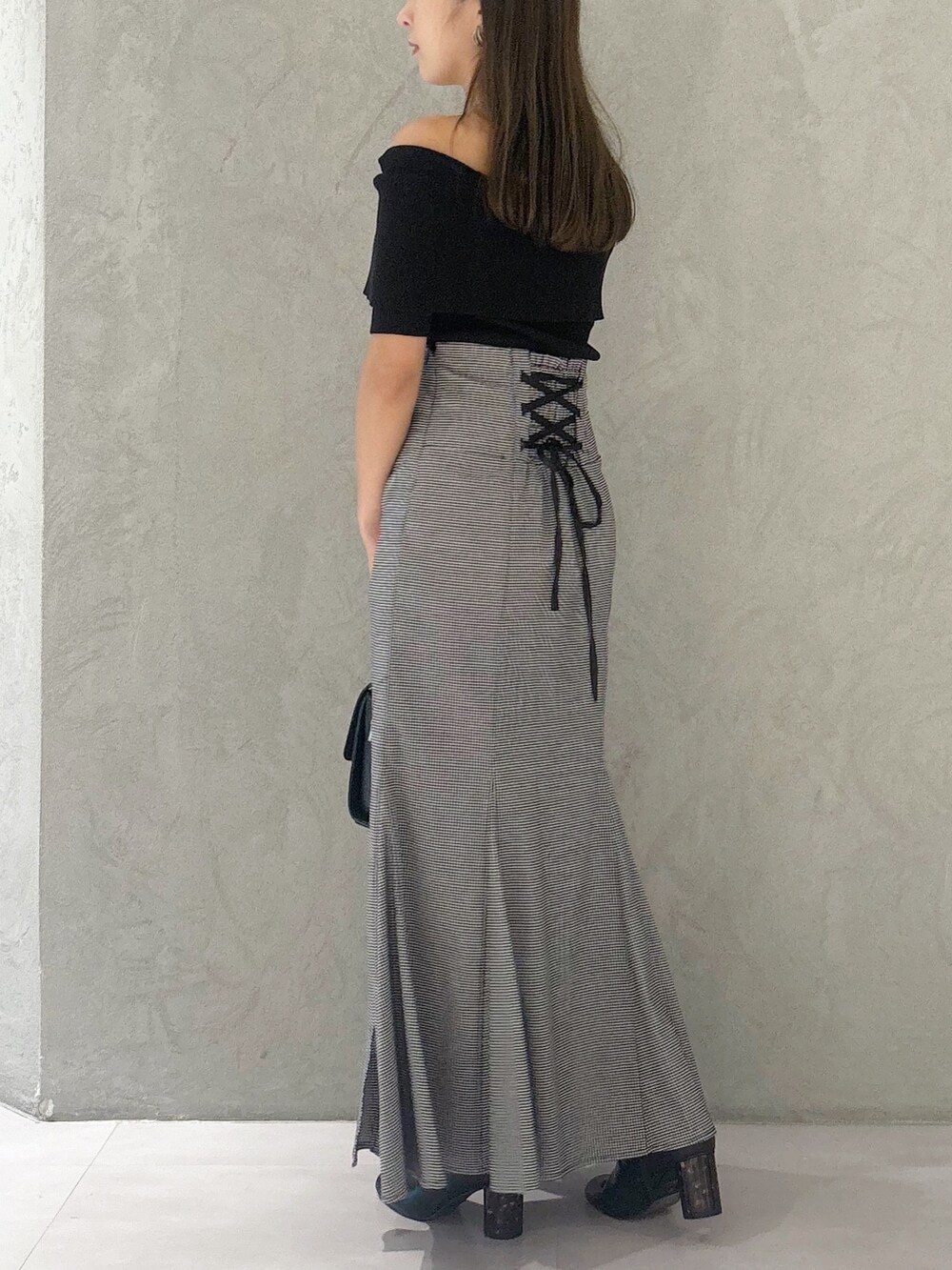 その他のスカート、ブラック系のブーツ、ブラック系のショルダーバッグを着用したレディースの秋コーディネートの3枚目の写真