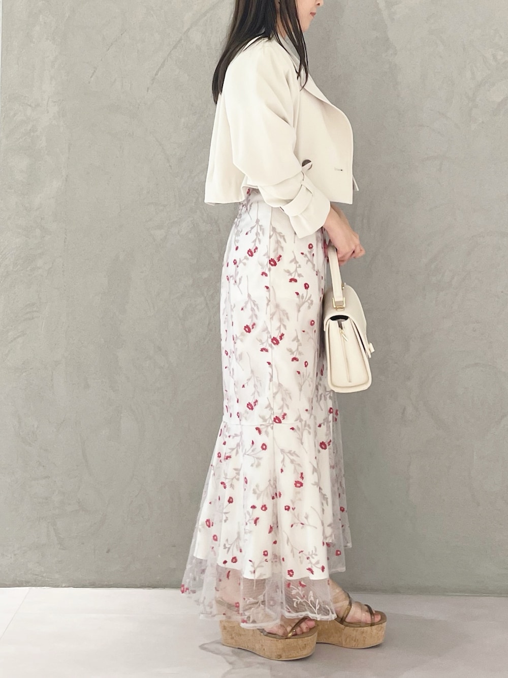 レッド系のワンピース、ブラウン系のサンダル、ホワイト系のショルダーバッグを着用したレディースの春コーディネートの3枚目の写真