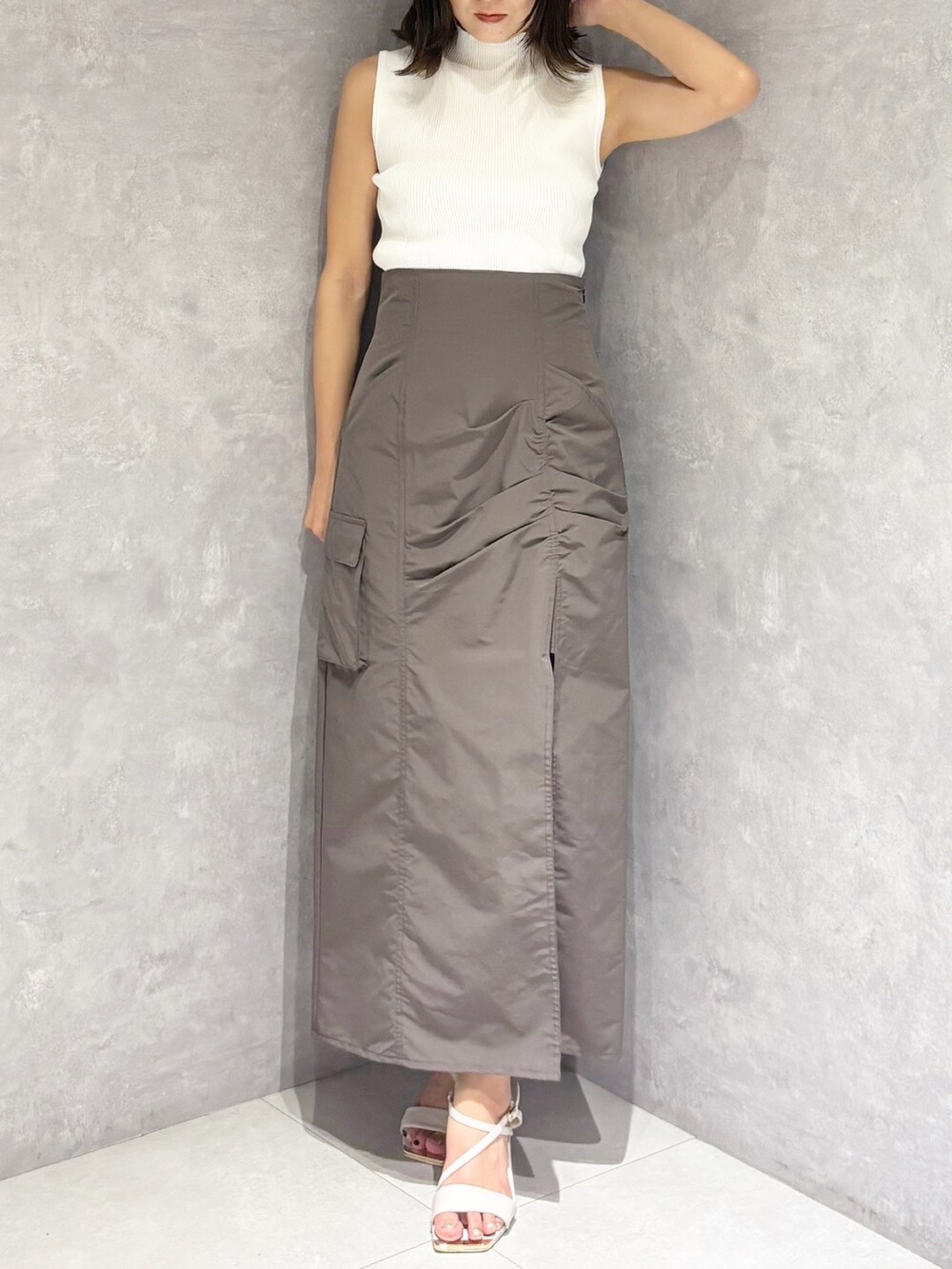 ブラウン系のスカート、ホワイト系のサンダル、ホワイト系のニット/セーターを着用したレディースの夏コーディネートの6枚目の写真